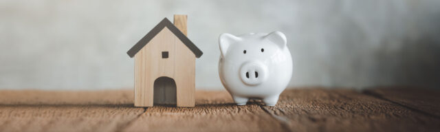 white piggy bank next to model house