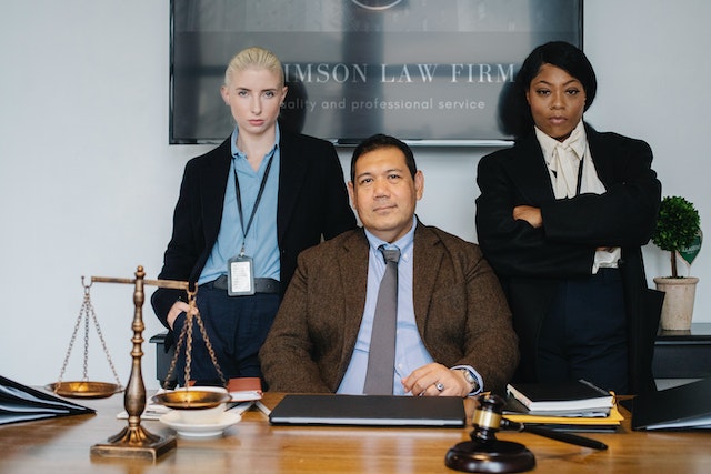 lawyers sitting and standing near desk